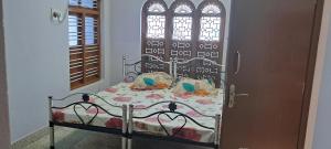 a bed in a room with a window and a door at Major Madi Residency in Puducherry