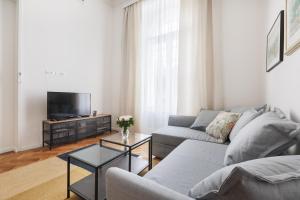 Una sala de estar con un sofá y un televisor. en Cozy in the heart of Zagreb - H, en Zagreb