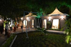 a house with lights in the yard at night at The Whispering Palms Resort in Bhopal