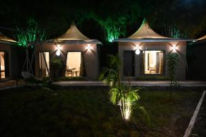 a house with lights in the yard at night at The Whispering Palms Resort in Bhopal