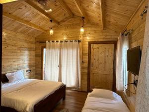 a bedroom with two beds in a wooden cabin at Coorg Jungle Mist in Madikeri