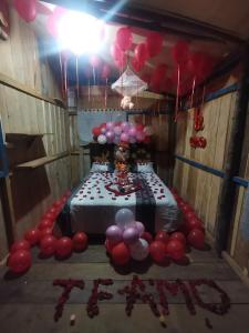 una habitación con una mesa con globos y un pastel en YAKU lodge & camping en Padre Cocha