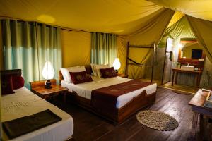 um quarto com 2 camas numa tenda em River Glamping by Gaga bees em Udawalawe