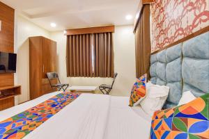 a hotel room with a bed and a television at FabExpress Md in Vadodara