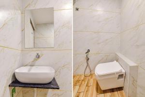 een badkamer met een wit toilet en een spiegel bij FabExpress Md in Vadodara