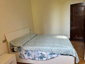 a small bedroom with a bed with a blue comforter at Villa Tirotti in Piacenza