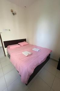 a bedroom with a pink bed with two pillows on it at Intanova Hotel in Teluk Intan