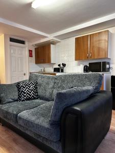 uma sala de estar com um sofá e uma cozinha em Entire Apartment boutique king size bed near Town Centre em Colchester