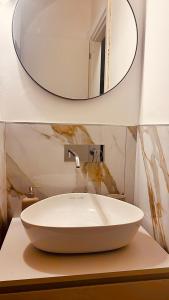 uma casa de banho com um lavatório branco e um espelho. em Lagrange 34 em Turim