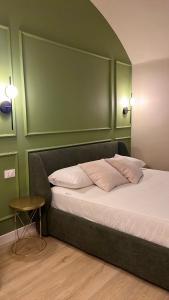 a bedroom with a bed with a green headboard and a table at Lagrange 34 in Turin