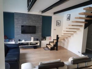 a living room with a staircase and a tv at 9 pers 160 M² +jardin- 10mn Nantes -30mn mer in Bouguenais