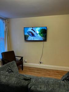 uma sala de estar com um sofá e uma televisão na parede em Entire Apartment boutique king size bed near Town Centre em Colchester