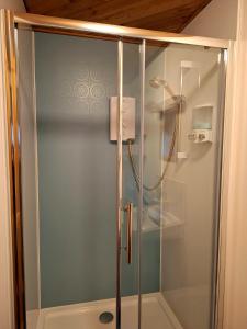 a shower with a glass door in a bathroom at Kishorn Seaside House - Bed and breakfast in Strathcarron