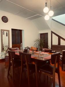 a dining room with a table with chairs and a clock at Kandy Boutique Villa by Aaradhya in Kandy