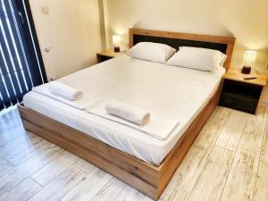 a bedroom with a large bed with white sheets and pillows at Xelibri Apartment in Gorna Oryakhovitsa
