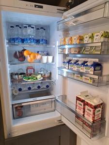 an open refrigerator filled with lots of food and drinks at SeaView Apartment Suite in Cobh