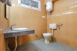 a bathroom with a toilet and a sink at FabHotel Nirvana Deluxe in Manāli