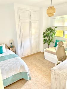 a bedroom with two beds and a chair at Casa Oikos - La Cala de Mijas in La Cala de Mijas