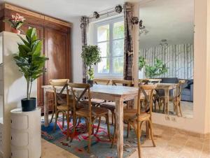 a dining room with a wooden table and chairs at Le cottage de David in Pierrefonds