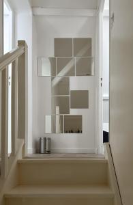 uma escadaria com paredes brancas e prateleiras brancas em Le cottage de David em Pierrefonds