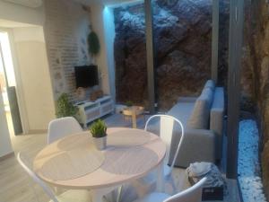 a living room with a table and a couch at El susurro del tajo La gruta in Toledo