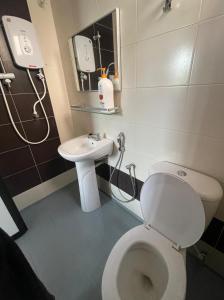 a bathroom with a white toilet and a sink at Intanova Hotel in Teluk Intan