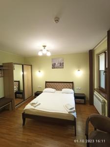um quarto com uma cama com lençóis brancos e almofadas em Явір Резорт em Starychi