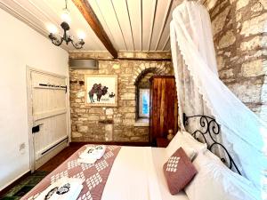 1 dormitorio con 1 cama en una pared de piedra en Marissa Boutique Hotel, en Cesme