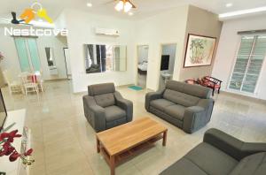 uma sala de estar com dois sofás e uma mesa de centro em Hidden Gem Villa Tengkera Malacca By Nestcove em Malaca