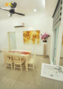 uma sala de jantar com uma mesa e cadeiras e um lavatório em Hidden Gem Villa Tengkera Malacca By Nestcove em Malaca