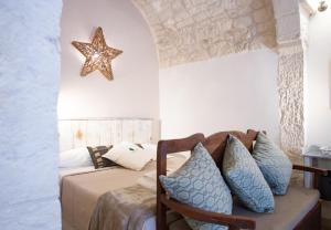 een slaapkamer met een bed met blauwe kussens bij Casa Paradiso - The Fab Stay in Ostuni