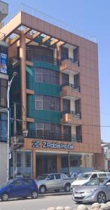Z Addis Hotel في أديس أبابا: مبنى فيه سيارات تقف امامه