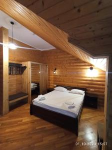 ein Schlafzimmer mit einem großen Bett in einem Holzzimmer in der Unterkunft Явір Резорт in Starychi