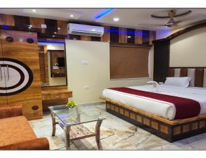 Hotel RREAMSO International, Muzaffarpur في مظفربور: غرفة نوم بسرير كبير وطاولة زجاجية