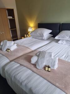 a bedroom with two beds with towels and rings on them at HEWORTH INN and ROOMS in York