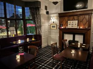 a restaurant with tables and chairs and a fireplace at HEWORTH INN and ROOMS in York