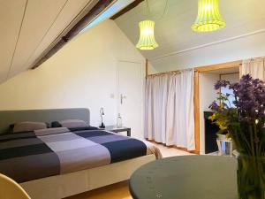 - une chambre avec un lit, une table et des fleurs dans l'établissement Duplex au coeur de Louveigné - Proche de Spa, à Sprimont