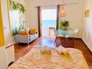 a room with a bed and a table with a view of the ocean at The Beachhouse Apartments in Vaia