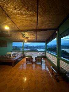a room with chairs and tables on a balcony at THADAN GUEST HOUSE in Ban Houayxay