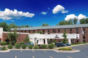 un gran edificio de ladrillo con coches aparcados en un aparcamiento en DoubleTree by Hilton Hotel Grand Rapids Airport, en Grand Rapids