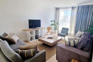 un soggiorno con 2 divani e una TV di Magnifique 3 pièces/terrasse/promenade des Anglais a Nizza