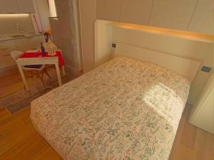 a small bedroom with a bed and a table at Casa Colibrì - Welcome to a Mountain Dream in Forni di Sopra