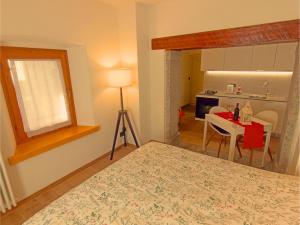 1 dormitorio con cama, mesa y cocina en Casa Colibrì - Welcome to a Mountain Dream, en Forni di Sopra