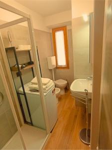 a bathroom with a toilet and a sink at Casa Colibrì - Welcome to a Mountain Dream in Forni di Sopra