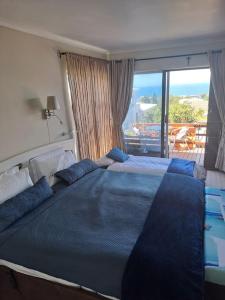 een slaapkamer met een groot bed met een groot raam bij Captains View in Jeffreys Bay