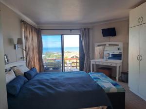 een slaapkamer met een bed en uitzicht op de oceaan bij Captains View in Jeffreys Bay
