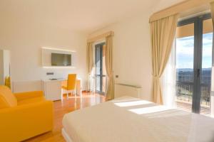 una camera d'albergo con un letto e una grande finestra di Hotel Palazzo Bello a Recanati