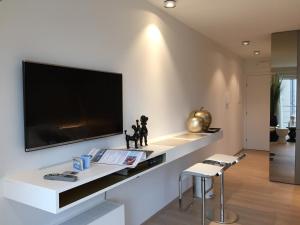 a living room with a large flat screen tv on a wall at Sleep at Sea in Nieuwpoort