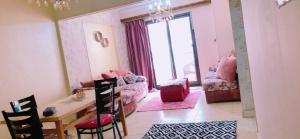 un soggiorno con tavolo e sedie e una camera con finestra di Cozy Apartment in Maadi ring road with smart TV a Il Cairo
