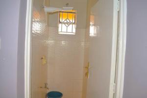 a bathroom with a shower with a toilet and a window at EnZ lovely 2 bedroom Apartment Milimani Nakuru in Nakuru +10 photos